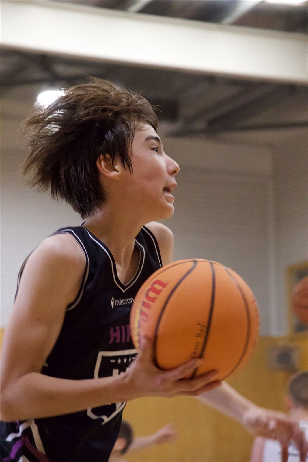 Junior player in a HIPE singlet finishing at the rim